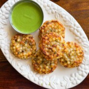 Crispy crunchy golden brown sabudana vadas served on a white platter with green mint chutney