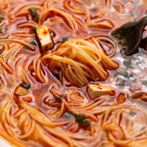 a close up image of spicy noodle soup to show it's consistency and texture