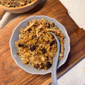 claypot mushroom rice served in a bowl with spoon