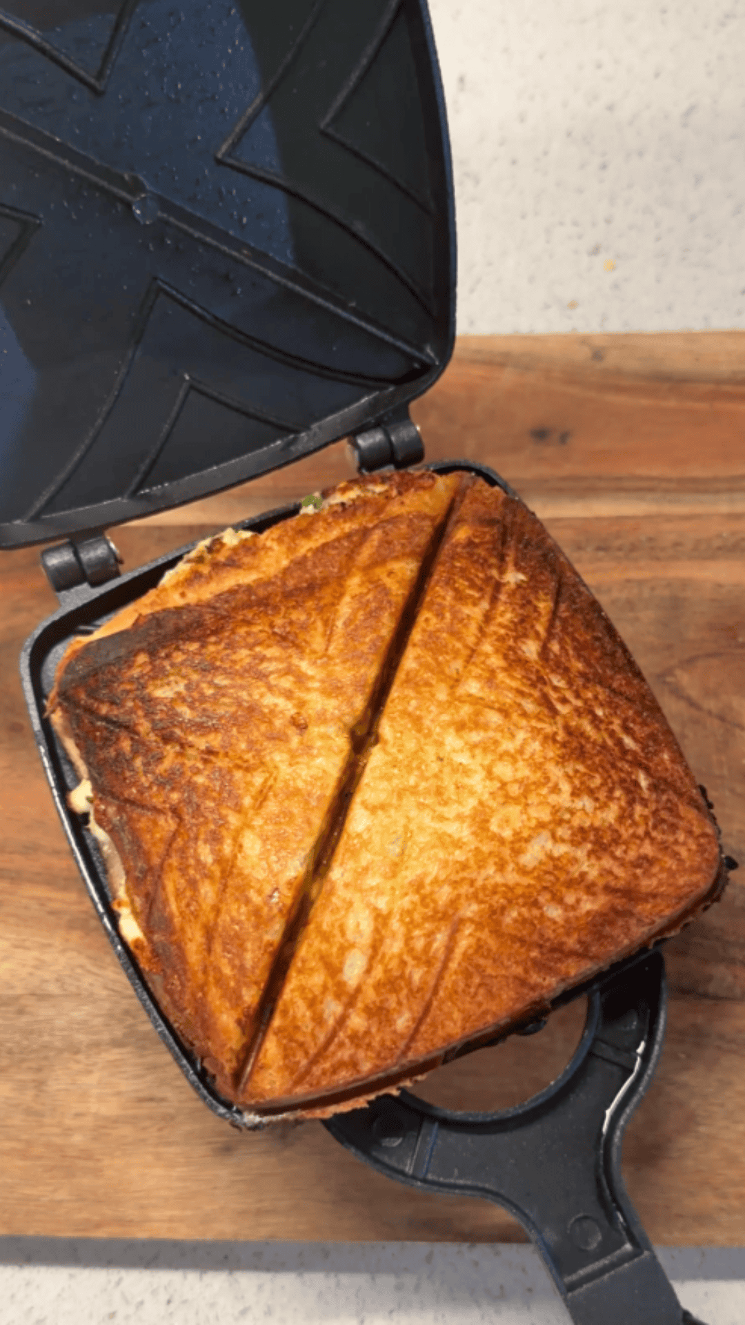 thecha paneer sandwich freshly made, still in the sandwich maker