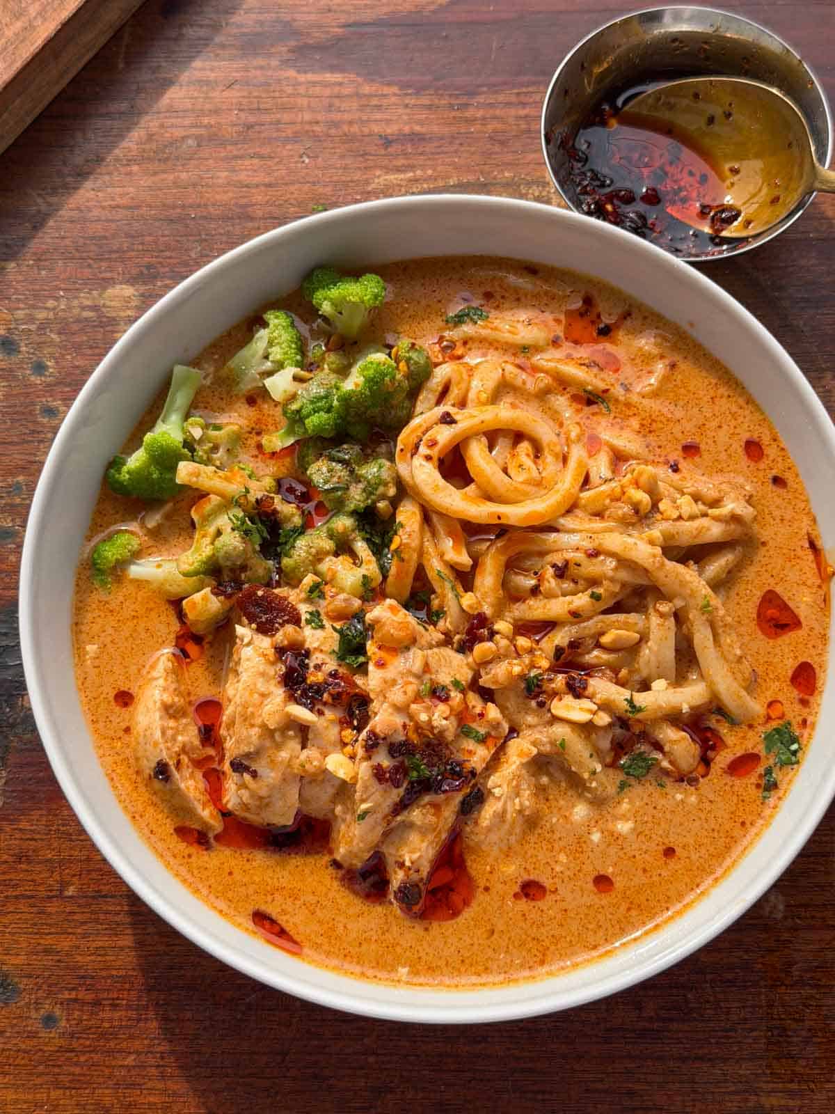 peanut butter ramen noodles served in a white bowl with chilli oil