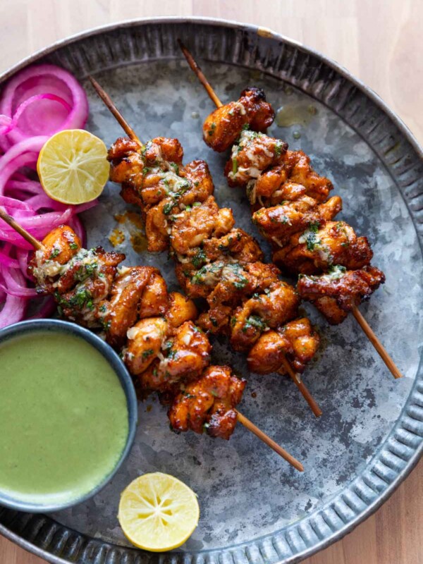 an image of achari chicken tikkas served in a plate with accompaniments