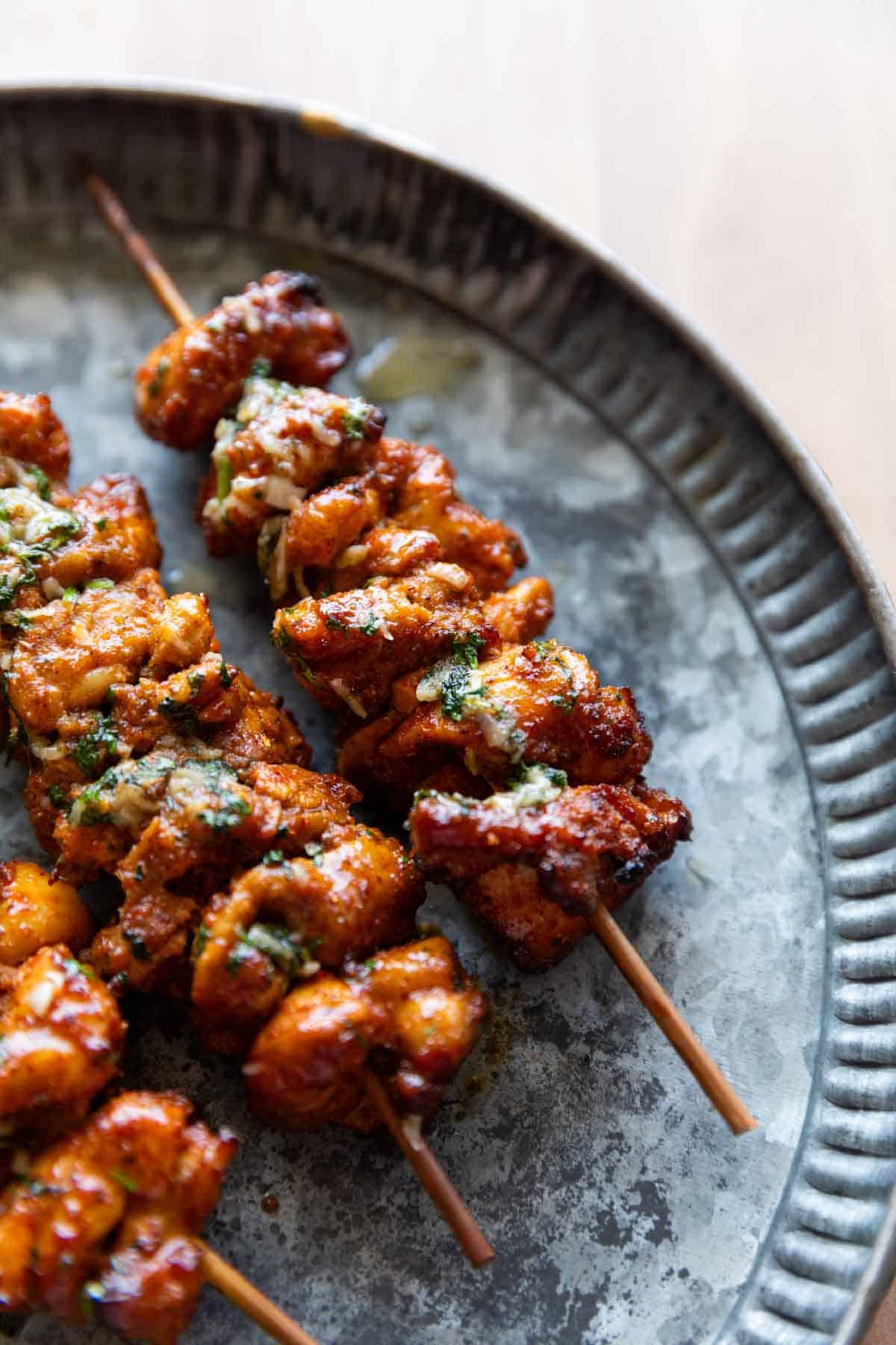 a close up image of achari chicken tikkas served on a plate