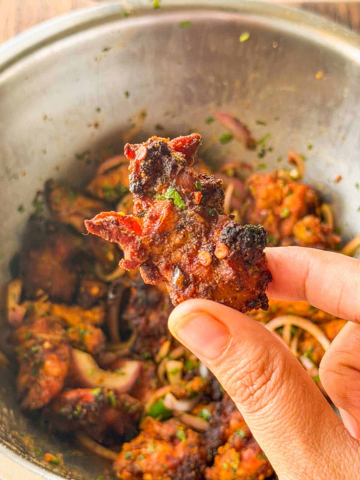 an image of a person holding a chicken bite to showcase it's color and texture
