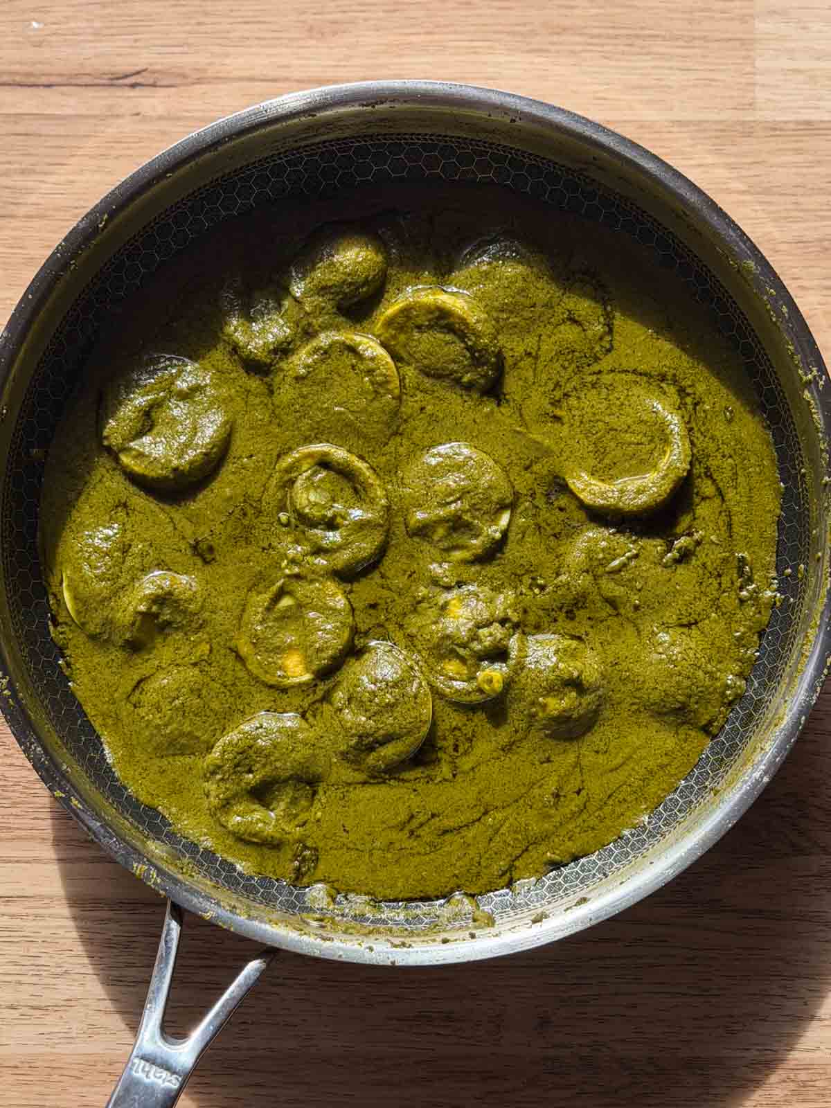 green egg curry in it's cooking vessel ready for serving