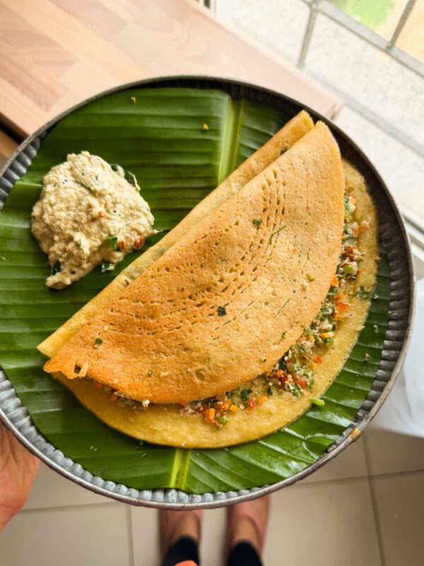 Stuffed Moong Dal Chilla served with chutney on the side on a banana leaf plate