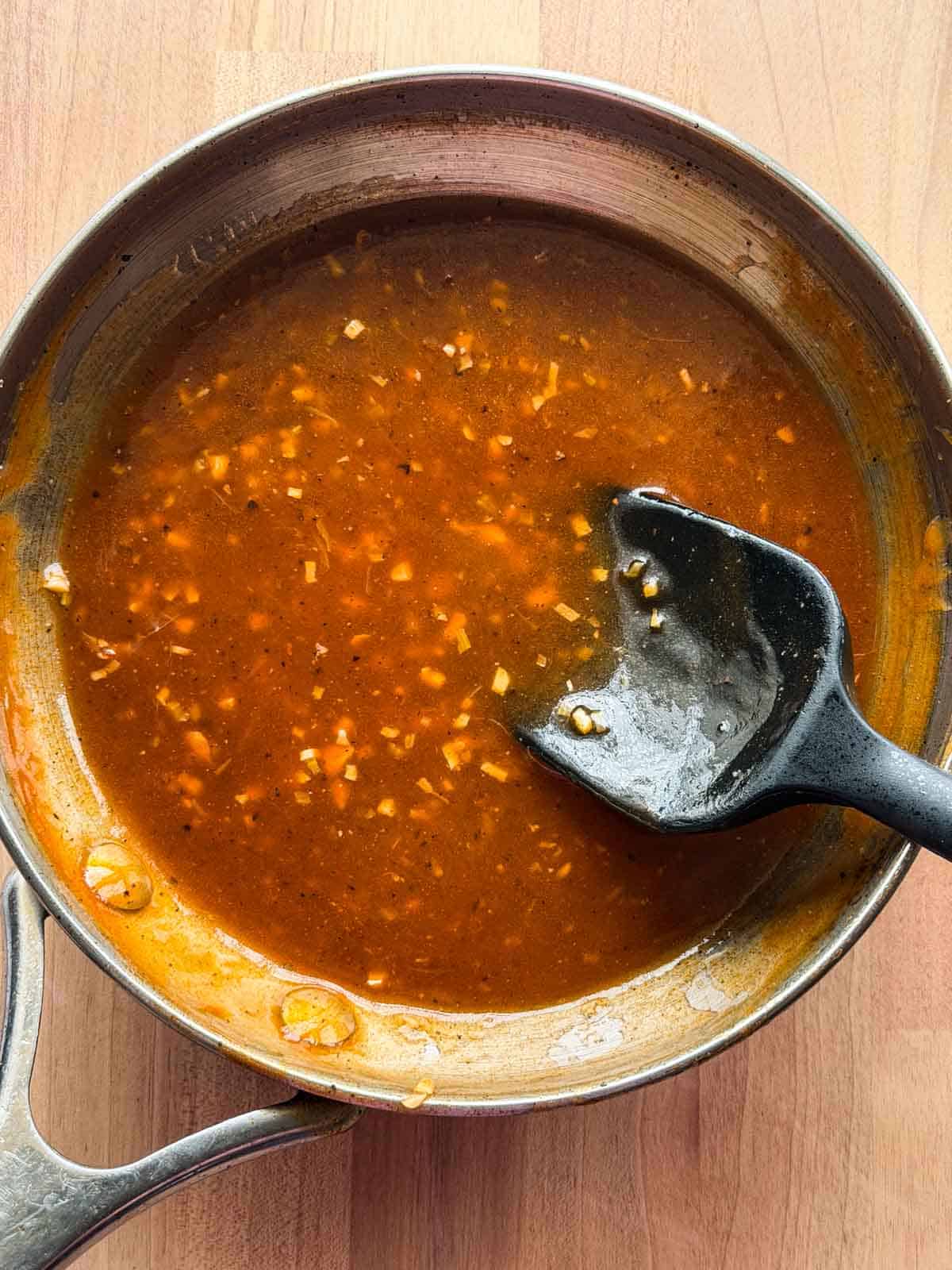 shashlik sauce in its cooking pan with ladle