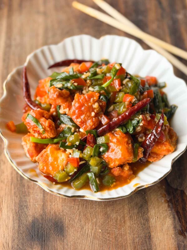 crispy chili tofu served in a white bowl with chopsticks