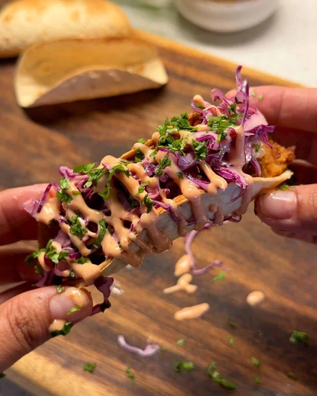 a person holding a Mexican paneer taco